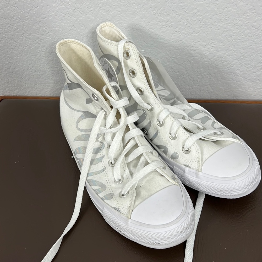 white Converse All Stars in size 8, brand new with tags, a silver Converse side